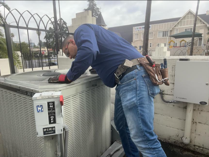 HVAC technician repairing an air conditioning unit to improve cooling efficiency.