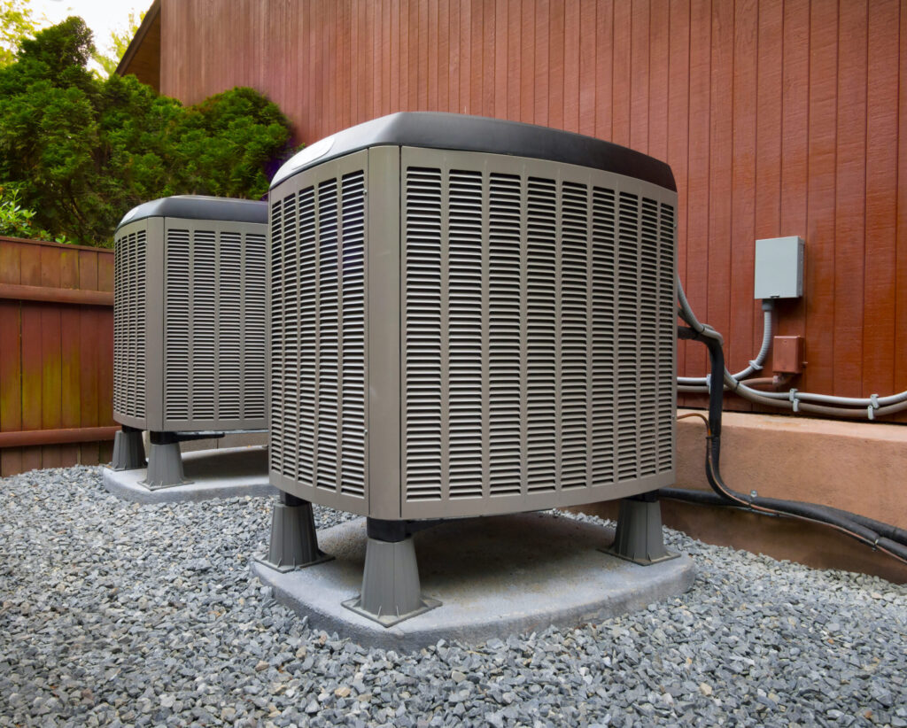 Two high-efficiency air conditioning units outside an apartment complex, providing cooling for multiple units.